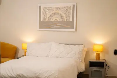a bedroom with a white bed with two lamps at San Isidro Urban Suite in Juan López