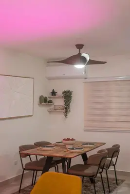a dining room table with chairs and a ceiling fan at San Isidro Urban Suite in Juan López