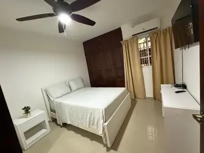 a bedroom with a bed and a ceiling fan at Getaway paradise in Los Mameyes