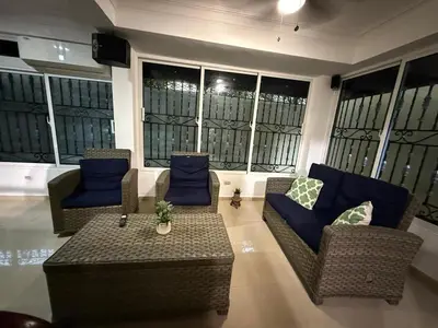 a living room with couches and a table and windows at Getaway paradise in Los Mameyes