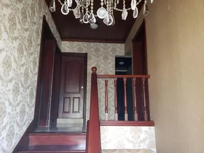 a staircase with a brown door and a chandelier at Getaway paradise in Los Mameyes