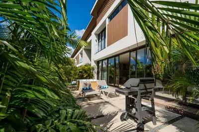 an outdoor patio with a grill and a table at Luxury Guesthouse Villa with Golf Cart - Casa de Campo in La Romana