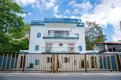 a white building with a fence in front of it at oceanfront apartment in La Puntica de Juan Dolio