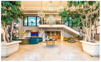 a lobby with palm trees and a chandelier at Luxury Awaits at Casa de Campo A Stunning Five-Bedroom Retreat in La Romana
