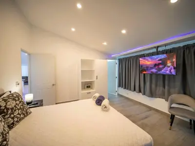 a bedroom with a bed and a tv on a wall at Luxury 3BR Penthouse 300m from beach in Sosúa
