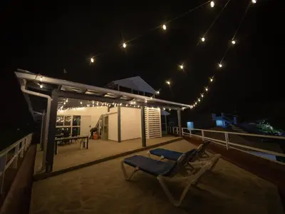 a couple of chairs sitting on a deck at night at Luxury 3BR Penthouse 300m from beach in Sosúa