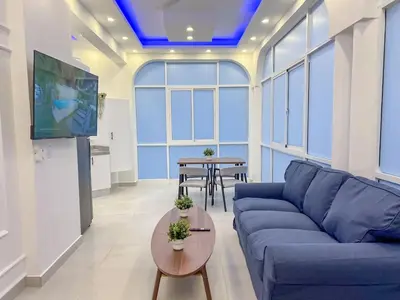 a living room with a blue couch and a table at Plaza Achim 7 Luxury Apt 250m from Sosua Beach in Sosúa