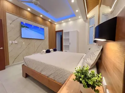 a bedroom with a bed and a tv on a wall at Plaza Achim 7 Luxury Apt 250m from Sosua Beach in Sosúa