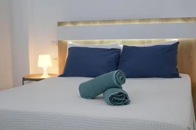a bed with blue pillows and a green towel on it at Spacious 3BR Residence in Punta Cana by Infinity Homes in Punta Cana