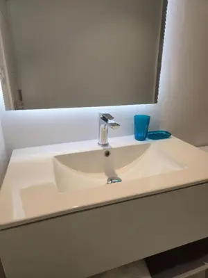 a bathroom sink with a mirror and a blue glass at Spacious 3BR Residence in Punta Cana by Infinity Homes in Punta Cana