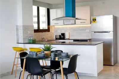 a kitchen with a table with chairs and a refrigerator at Spacious 3BR Residence in Punta Cana by Infinity Homes in Punta Cana