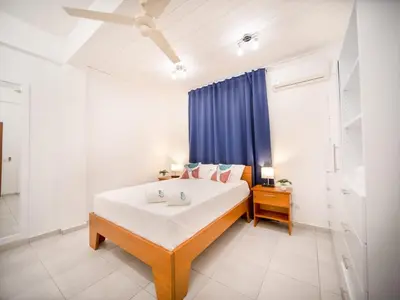 a bedroom with a bed and a blue curtain at Plaza Achim 6A, Modern APT 250m from Sosua beach! in Sosúa