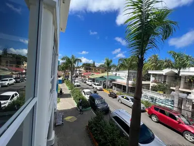 a view from a window of a street with cars parked at Plaza Achim 6A, Modern APT 250m from Sosua beach! in Sosúa