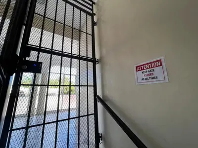 a metal door with a sign on it next to a building at Plaza Achim 6A, Modern APT 250m from Sosua beach! in Sosúa