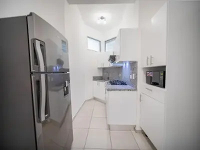 a kitchen with white cabinets and a refrigerator at Plaza Achim 6A, Modern APT 250m from Sosua beach! in Sosúa