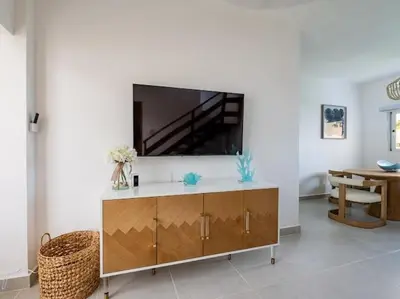 a living room with a flat screen tv on a wall at Rooftop Penthouse Jacuzzi, 2 Pools Playa Popy 500m in Las Terrenas