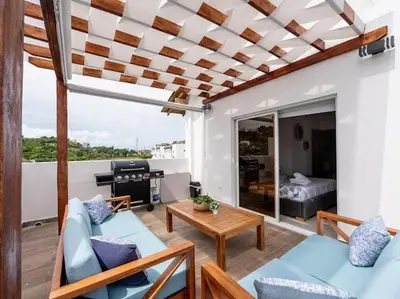 a living room with a couch and a table at Rooftop Penthouse Jacuzzi, 2 Pools Playa Popy 500m in Las Terrenas