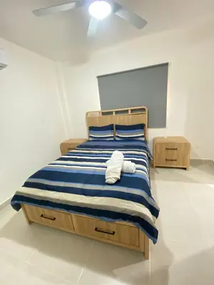 a bedroom with a bed with blue and white stripes at 3 bedroom apartment in Armonía Las Terrenas in Las Terrenas