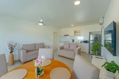 a living room with a table and chairs and a kitchen at Prime Apartment with Fast Internet & Washer in SOV in Sosúa