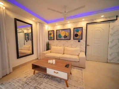 a living room with a white couch and a table at Garden Condos 5 - Ultra Modern Apartment in Sosua in Sosúa