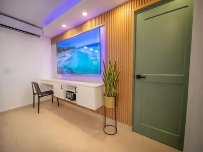 a room with a fish tank on the wall and a door at Garden Condos 5 - Ultra Modern Apartment in Sosua in Sosúa