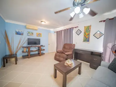 a living room with a couch and a chair and a television at Garden Condos 9 Affordable APT in Sosua downtown in Sosúa