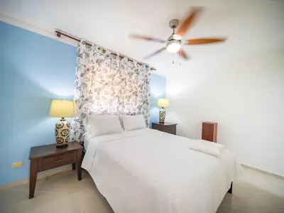 a bedroom with a white bed and a ceiling fan at Garden Condos 9 Affordable APT in Sosua downtown in Sosúa