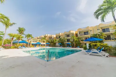a pool at the resort with chairs and umbrellas at Garden Condos 10 2BR Apt in Sosua Strip in Sosúa
