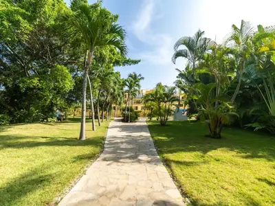 a path through a park with palm trees at Garden Condos 10 2BR Apt in Sosua Strip in Sosúa