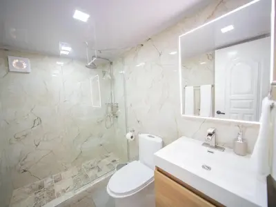 a bathroom with a toilet and a sink and a mirror at Garden Condos 21 Modern 1BR APT in Sosua Strip in Sosúa