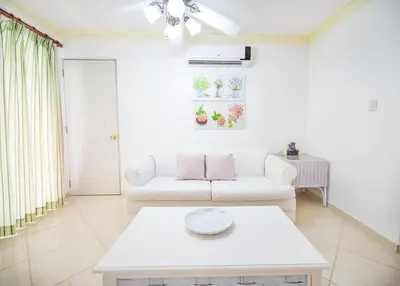 a living room with a white couch and a table at Garden Condos APT 30 Lovely 1BR Condo with Pool in Sosúa