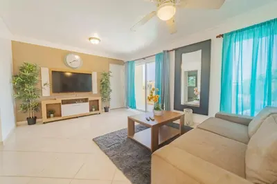 a living room with a couch and a tv at Garden Condos 35 Best Stylish apartment in Sosua in Sosúa