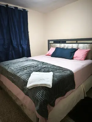 a bedroom with a large bed with pink and blue pillows at Espacio acogedor y funcional in SJM