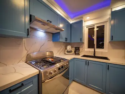 a kitchen with blue cabinets and a stove top oven at Garden Condos 39 Ultra modern apartment in Sosua in Sosúa