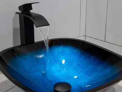 a bathroom sink with blue water pouring into it at Garden Condos 39 Ultra modern apartment in Sosua in Sosúa
