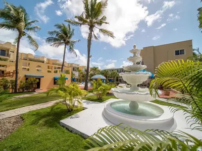 a fountain in the middle of a park with palm trees at Garden Condos 39 Ultra modern apartment in Sosua in Sosúa