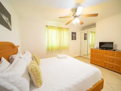 a bedroom with a bed and a ceiling fan at Charming 1BR Apt with Pool Walk to Sosua Beach in Sosúa