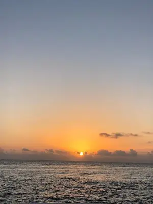 a sunset over the ocean with the sun setting at Luxury Penthouse with roof top & infinitive pool ocean view in Tracadero Beach Club in Bayahibe