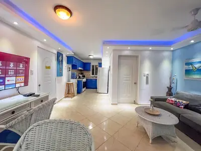 a living room with a couch and a table at Garden Condos 43 Modern Condo in Sosua center in Sosúa
