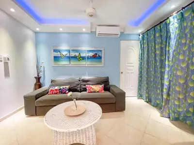 a living room with a couch and a table at Garden Condos 43 Modern Condo in Sosua center in Sosúa