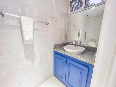 a bathroom with a sink and a glass shower at Garden Condos 43 Modern Condo in Sosua center in Sosúa