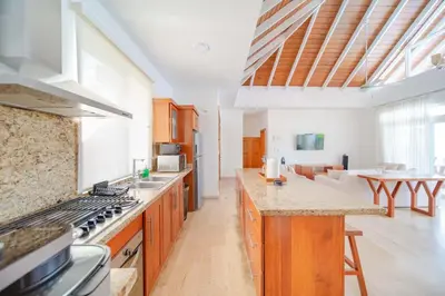 a large kitchen with wooden cabinets and a counter top at Luxury 2BR Villa next to Santa Fe in Sosúa