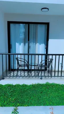 two chairs on a balcony with glass doors at Appartement lumineux, piscine & plage proche in Punta Cana