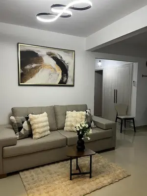 a living room with a couch and a table at Appartement lumineux, piscine & plage proche in Punta Cana