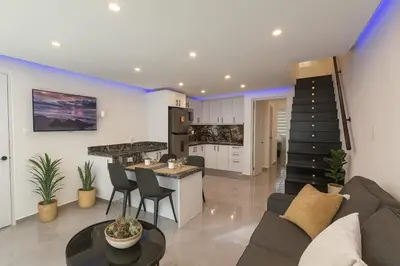 a kitchen and living room with a couch and a table at Stylish Sosua 2 BR apartment near everything in Sosúa