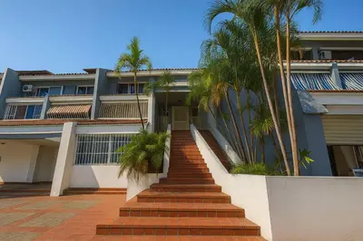 a staircase leading to a house with palm trees at Stylish Sosua 2 BR apartment near everything in Sosúa
