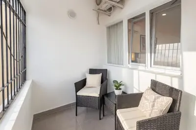 a balcony with two chairs and a table at Stylish Sosua 2 BR apartment near everything in Sosúa