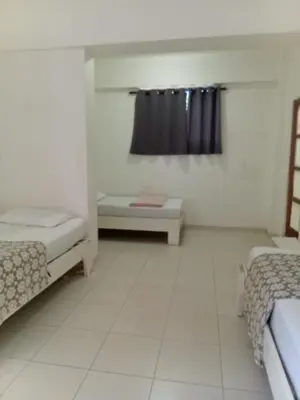 a small room with two beds and a window at Yuloren Hostal 1 min del monumento & 5 de Agora Mall in Santiago de los Caballeros