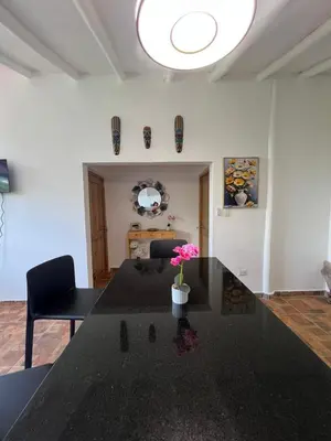 a dining room with a black table with a vase of flowers at Bright studio in the heart of Las Galeras in Las Galeras