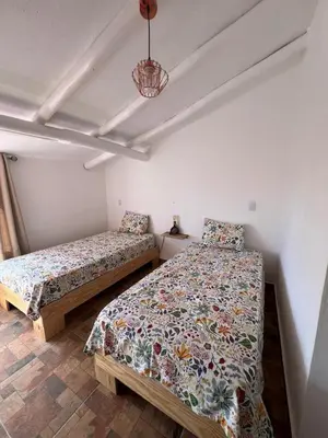 two beds in a room with white walls at Bright studio in the heart of Las Galeras in Las Galeras